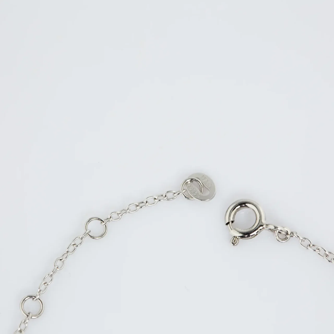 Delicate silver chain bracelet with a single white pearl centerpiece.