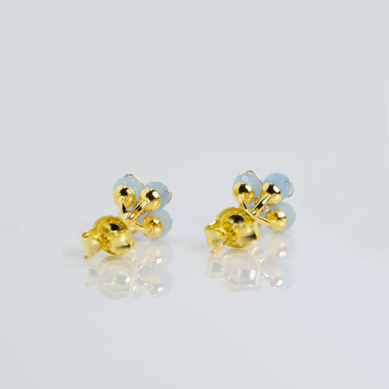 Stylish Blue Aquamarine flower stud earrings with gold accents, gemstones