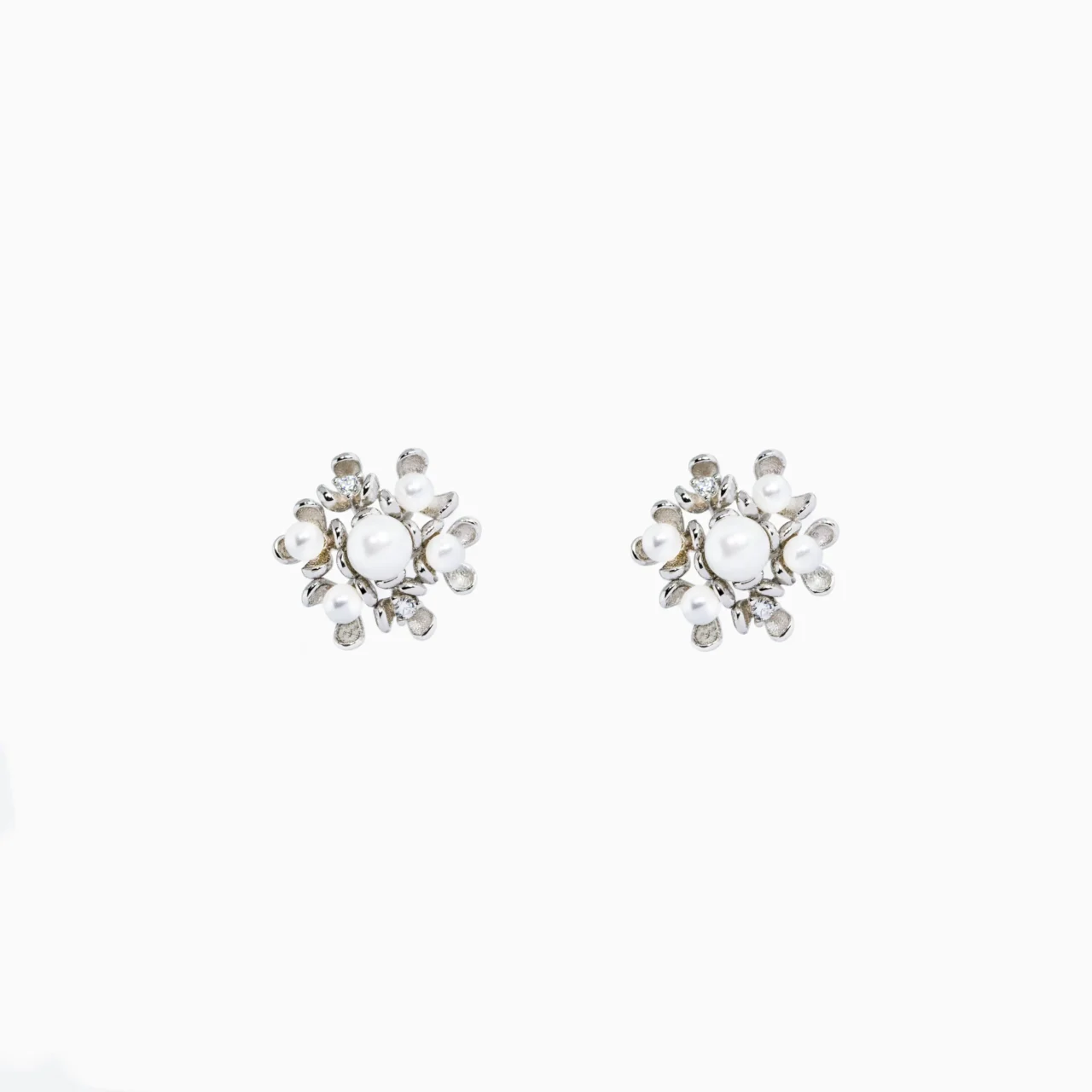 Intricate pearl and silver floral stud earrings with zirconia stones accents